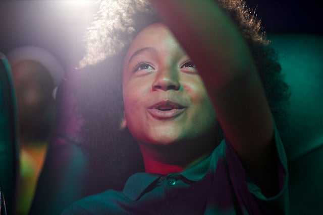 A kid is looking and pointing into the upper right position. 