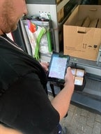 Sebastian prüft den Bestand mit einem Tablet.