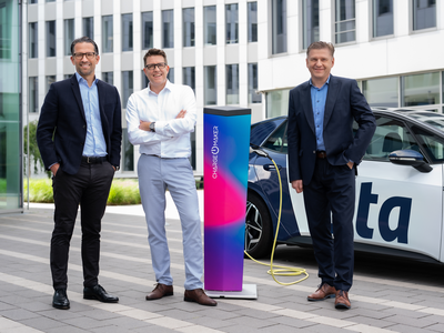 Dieses Bild zeigt drei Geschäftsmänner, die vor einem modernen Bürogebäude stehen. Alle tragen Businesskleidung. In der Mitte befindet sich eine Ladestation mit dem Logo „CHARGE MAKER“, die an ein Elektrofahrzeug angeschlossen ist. Das Fahrzeug hat das Logo der Firma „ista“ auf der Seite. Die Stimmung ist professionell, und die Szene deutet auf ein Thema im Bereich Elektromobilität und Nachhaltigkeit hin.