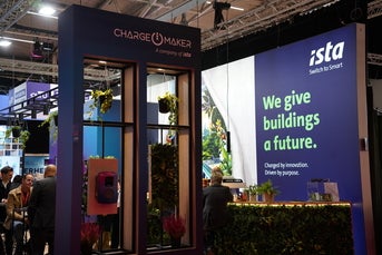 Messestand von ista und ChargeMaker mit grüner Pflanzenwand, Sitzbereich und dem Slogan „We give buildings a future.“ im Hintergrund, beleuchtet in moderner Atmosphäre.