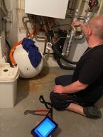 Kundendiensttechniker prüft Warmwasserzähler im Badezimmer.